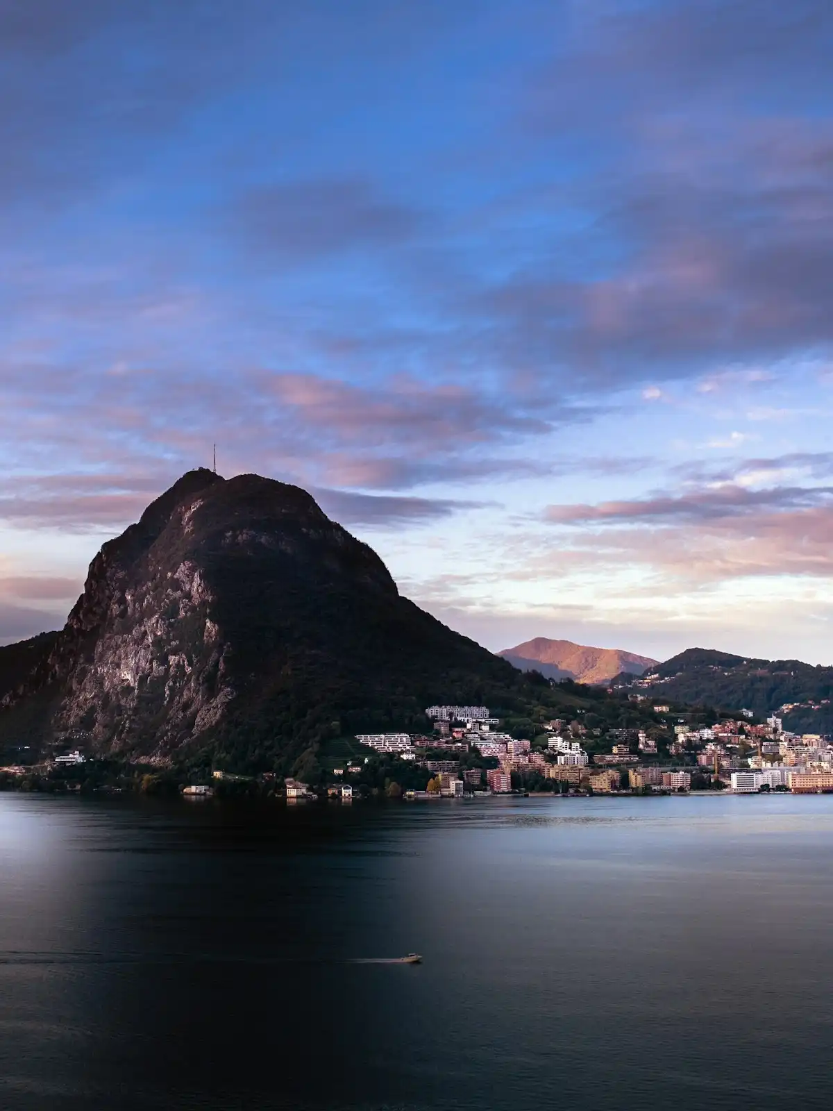 Body of water near mountain under cloudy sky during daytime — Lake Lugano, Switzerland