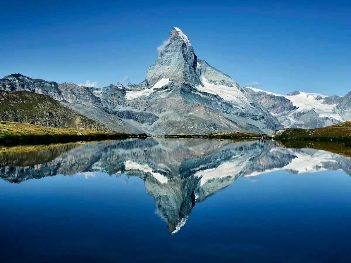 A mountain is reflected in the still water of a lake — Stellisee, Zermatt, Switzerland