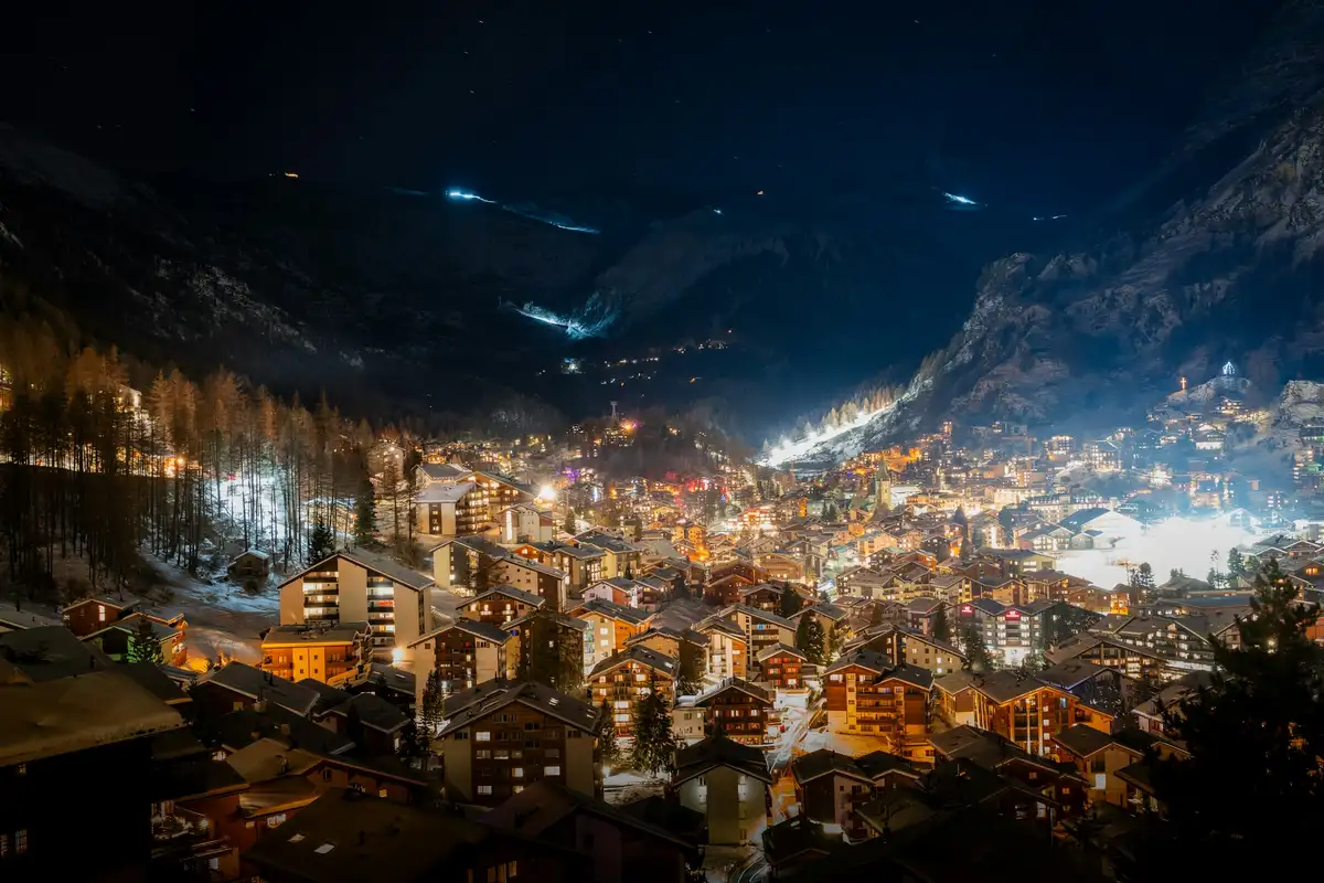 A view of a city at night from the top of a hill — Zermatt at night, Switzerland