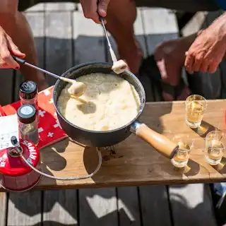 People dipping bread into a cheese fondue pot — Fondue, Switzerland